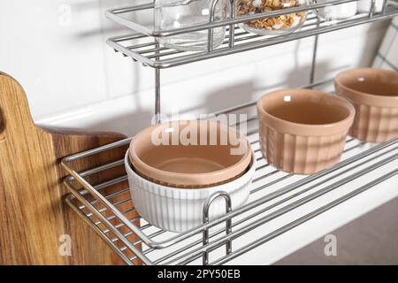 Many different ramekins on metal rack in kitchen Stock Photo