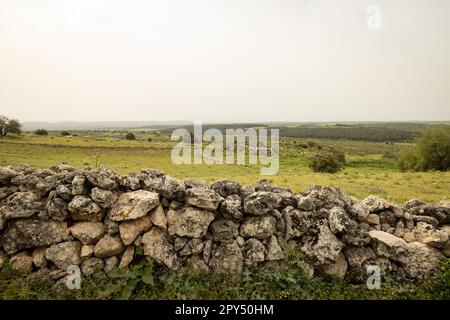 Old stone fence and beautiful green hills landscape Stock Photo