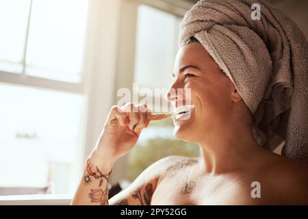 Hygiene before anything else. an attractive young woman brushing her teeth in the bathroom at home. Stock Photo