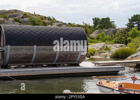 Gothenburg, Sweden - July 24 2022: Barrel shaped sauna placed on a wooden raft Stock Photo