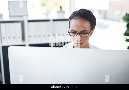 Keeping up to date with the latest news. a young doctor working on her computer. Stock Photo