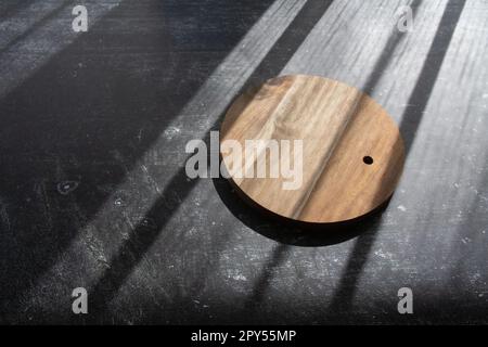 photo wooden round board on the table, the shadow of the window top view Stock Photo