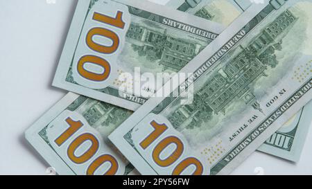 Flat lay of several one hundred 100 dollars banknotes bills on white background. Paper banknote, money, cash, currency. Stock Photo