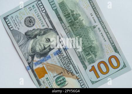Flat lay of two one hundred dollars banknotes bills greenbacks showing obverse and reverse sides on white background. Stock Photo