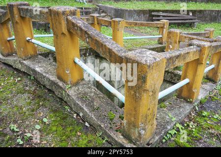 Banja Koviljaca, Loznica, Serbia. Mount Guchevo, park and forest. Source of mineral sulfuric and ferruginous water Rakina Chesma Cesma. A spring near the road to Guchevo. Concrete fence and stairs. Stock Photo