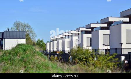 Terraced family homes in newly developed housing estate. The real estate market in the suburbs. New single family houses in a new development area. Stock Photo