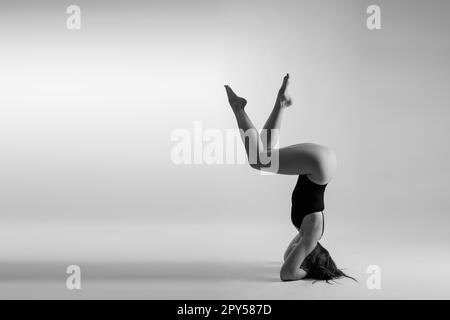 Portrait of beautiful young woman wearing black sportswear working out in studio. Full length. Stock Photo