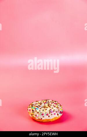 Sweet donuts stacked in a stack on a pink background. Copy space, various glaze and sprinkels chocolate chip, snack fast food sweets concept Stock Photo