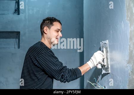 insulation of a concrete wall against moisture with the use of a trowel Stock Photo