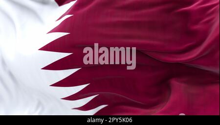 Detail of the Qatar national flag fluttering. The flag is maroon with a wide white wedge-shaped band. 3D illustration render. Close-up. Selective focu Stock Photo