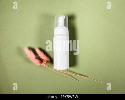 closed white blank plastic bottle lies on khaki Stock Photo