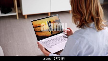 Watching TV Video On Laptop Online Stock Photo