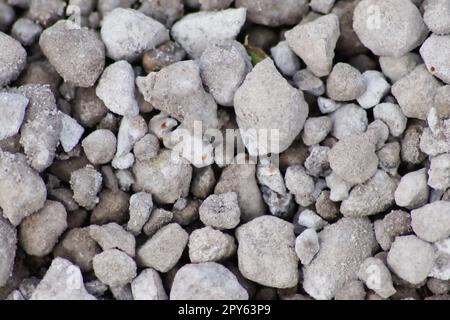 Gray raw rocks and rough stones as natural stones background with crushed and rough material as building material or rocky base for concrete mixture in gray colors as natural stones background Stock Photo