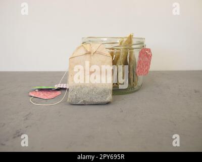 Used dried tea bags in a glass jar for homemade plant fertilizer for houseplants Stock Photo