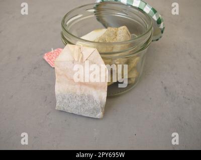 Used dried tea bags in a glass jar for homemade plant fertilizer for houseplants Stock Photo