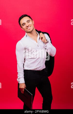 Image of young cheerful businessman in watch holding and using laptop isolated over red background Stock Photo