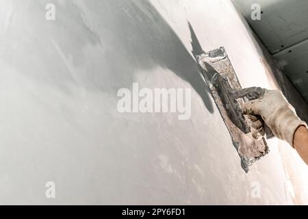 manual adjustment of wall plaster with trowel Stock Photo