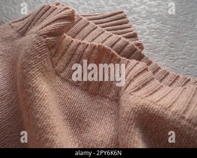 Knitted knitwear. Knitted warm winter sweater or close-up jumper. Wool or polyester threads. Clothing production. The texture of the knitted thing Stock Photo