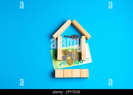 Wooden toy house with keys on blue. Empty space to put text or something else. Stock Photo