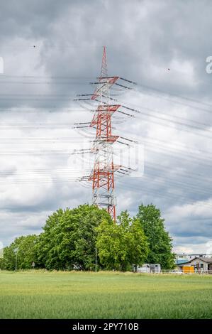 Electricity Pylon stripes white and red, view from low angle during cloudy day Stock Photo