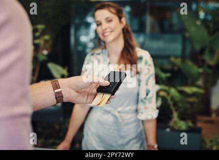 Punching in my pin. an unrecognizable man using his credit card to purchase from a florist. Stock Photo