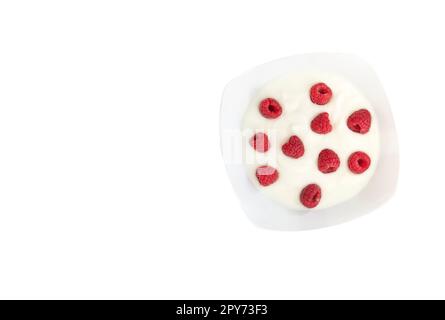 Rasberries in greek yogurt in a white boel isolated on a white background. Stock Photo