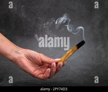 palo santo burning in front of dark background Stock Photo