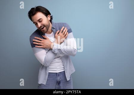 emotional young brutal brunette guy on a studio background for a poster Stock Photo