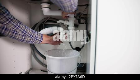 Plumber Fixing Pipe Leak Stock Photo