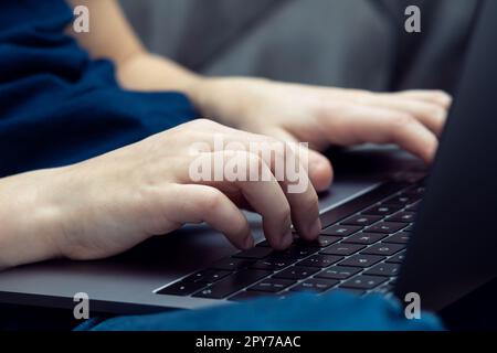Unrecognizable man hands typing, using laptop keyboard knees. E-learning and online school, programming, coding app Stock Photo