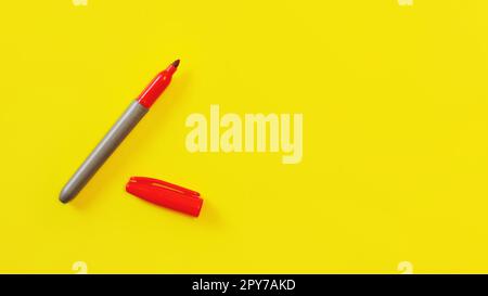 Top view on red marker, cap opened, on yellow board, copyspace for your text on right side. Stock Photo