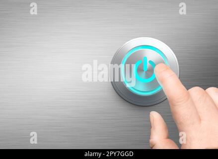 Finger about to press a power button polished metal background Stock Photo