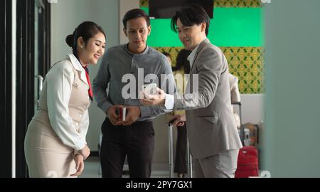 Man showing flight ticket to airline staff on phone. Airport check in counter and online air ticket.. Stock Photo