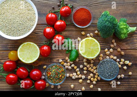 Assortment of quinoa and other superfood seeds and vegetables on wooden background. Vegetarian or vegan concept. Stock Photo