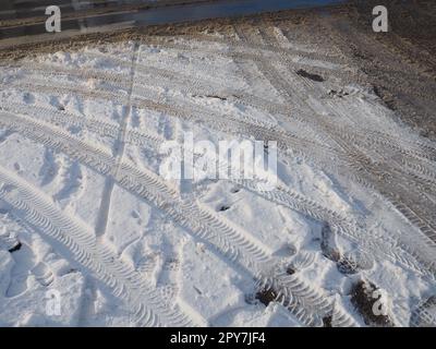 A fork or siding from a roundabout. Snowdrifts on the side of the road. Bad weather. Snow on asphalt. Difficult driving and traffic conditions. Winter slush on the road. Braking distance of a car Stock Photo