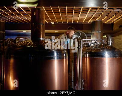 Copper boil kettle and distillery tanks in craft beer brewery Stock Photo