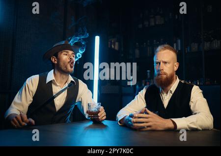 Stylish gangsters smoking hookah in bar having business meeting Stock Photo