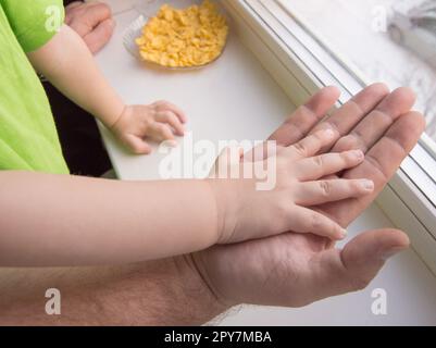 The child's hand rests on the palm of an adult male, child protection Stock Photo