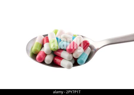 Colorful pills on spoon isolated on white background with clipping path Stock Photo
