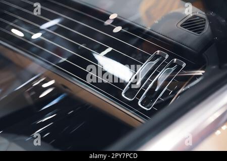 black interior of a luxurious car air conditioning system with leather dashboard details Stock Photo