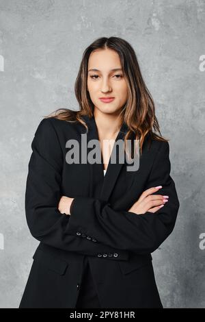 Medium closeup portrait of cute woman in black blazer with crossed arms Stock Photo