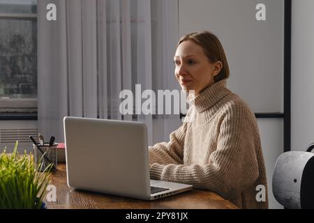 Middle-aged woman in love with her work works in office late at night Stock Photo
