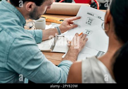 Once we dream it, we build it. Closeup shot of two architects working with blueprints in an office. Stock Photo