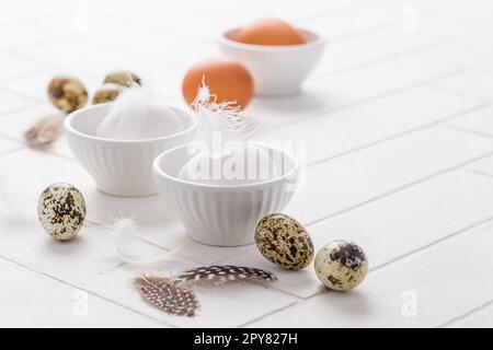 Different eggs with feathers for Easter on white background Stock Photo