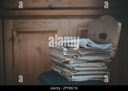 Stack of newspapers on a chair Stock Photo