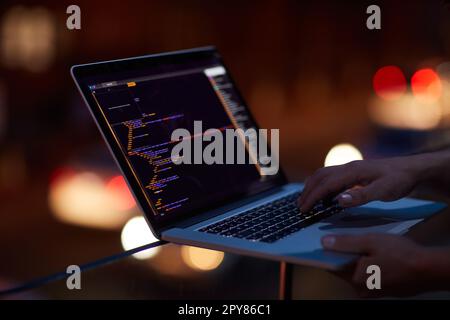 Dont become the next cybercrime victim. an unrecognisable hacker using a laptop in the dark. Stock Photo