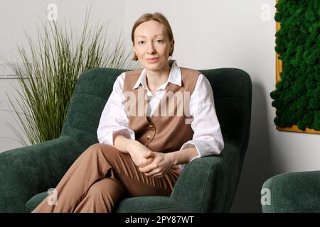 Portrait of cheerful middle aged woman in office rest room Stock Photo