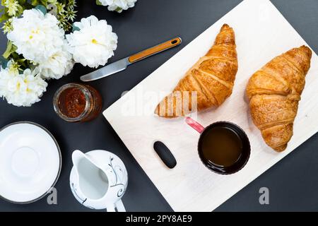 freshly baked croissants and cup of coffee on table, top view Stock Photo