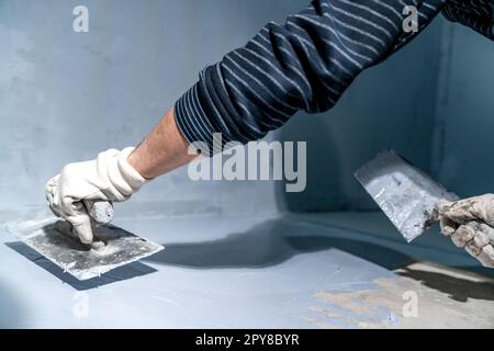 construction modifications of the floor and walls with trowel of a room in a new building Stock Photo