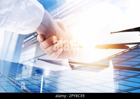 Two businessmen shake hands in agreement. Double exposure with light effect Stock Photo